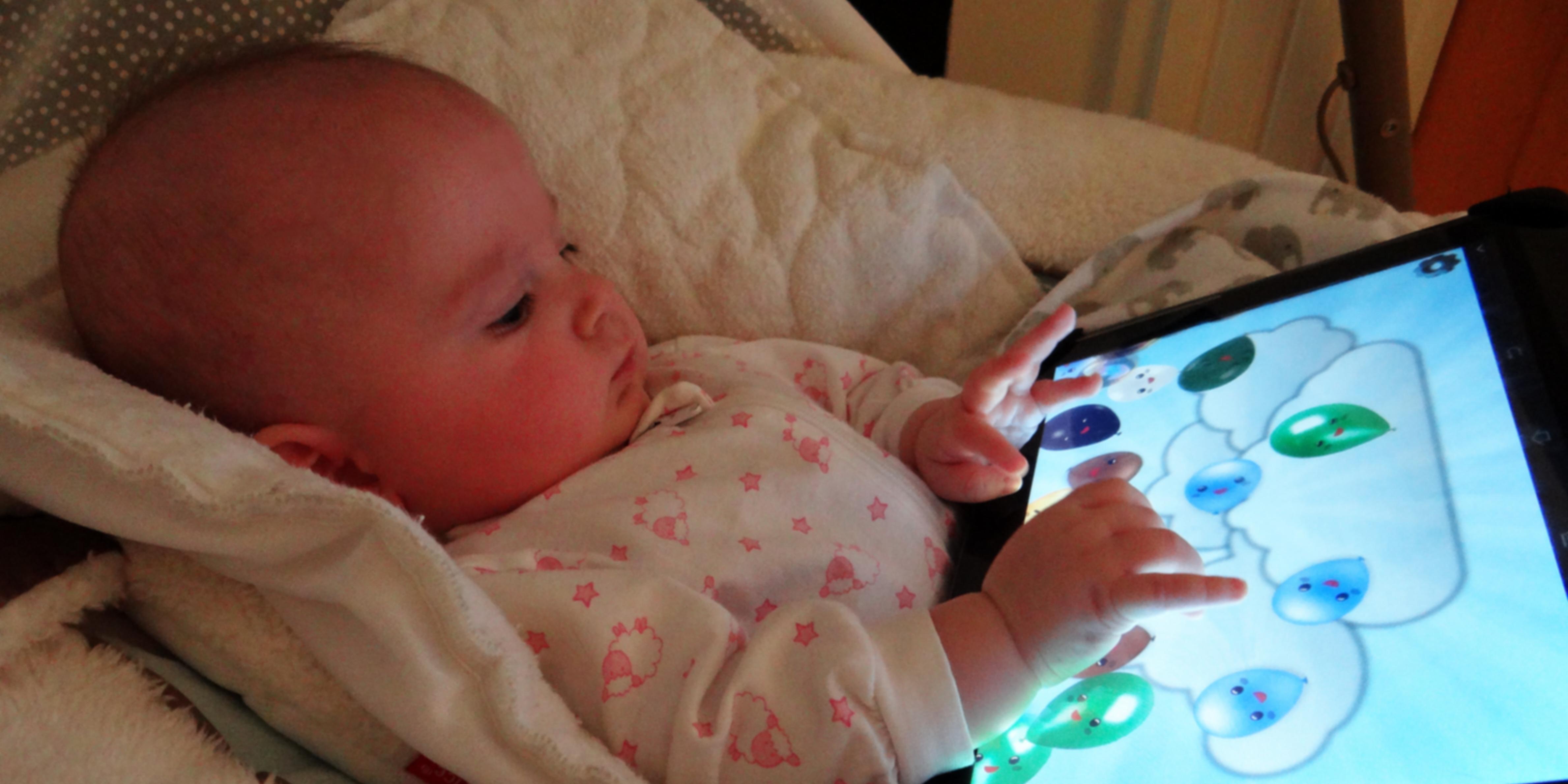 Infant playing Baby Balloons on a tablet.