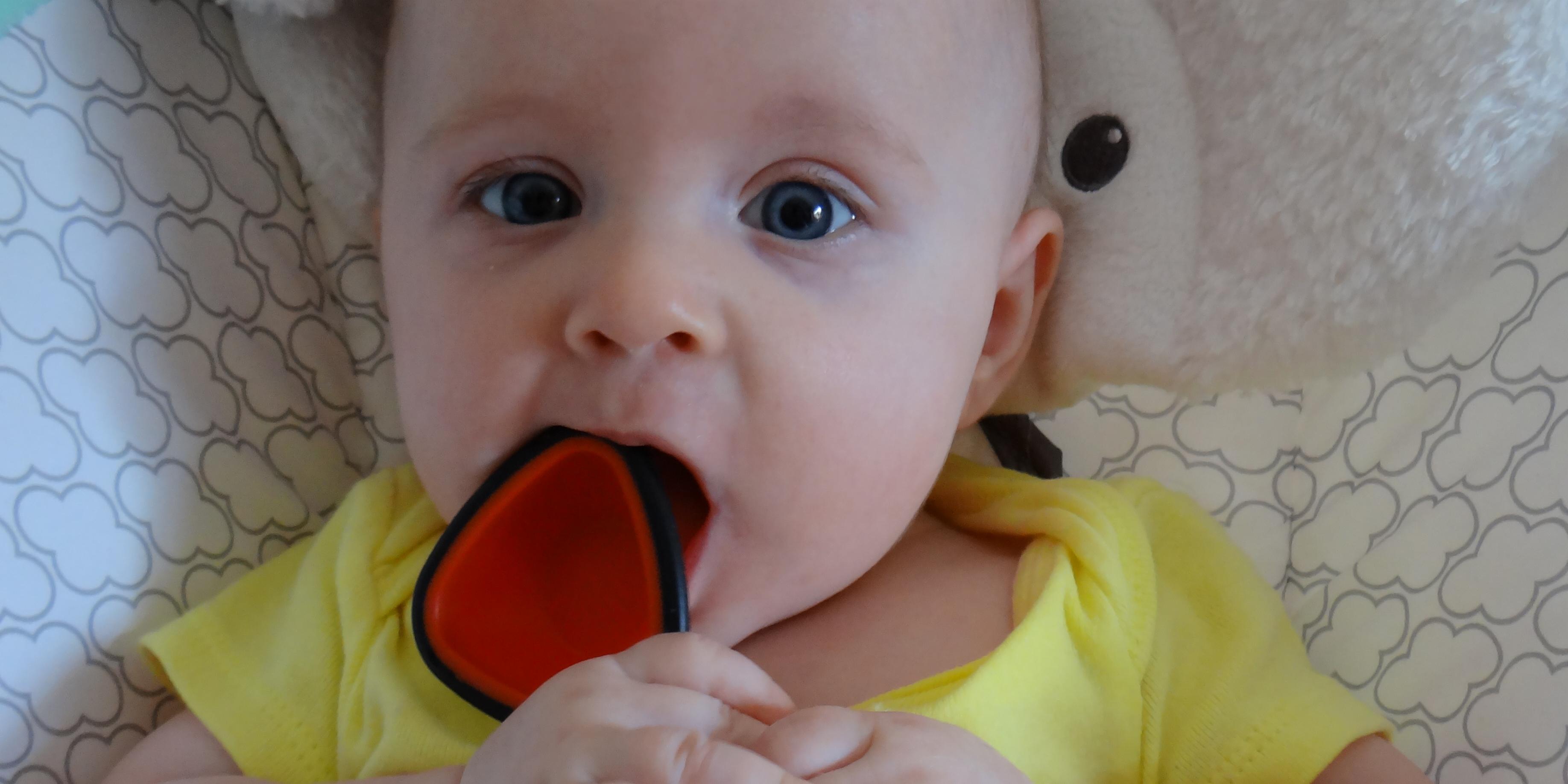 Baby tasting a measuring spoon.