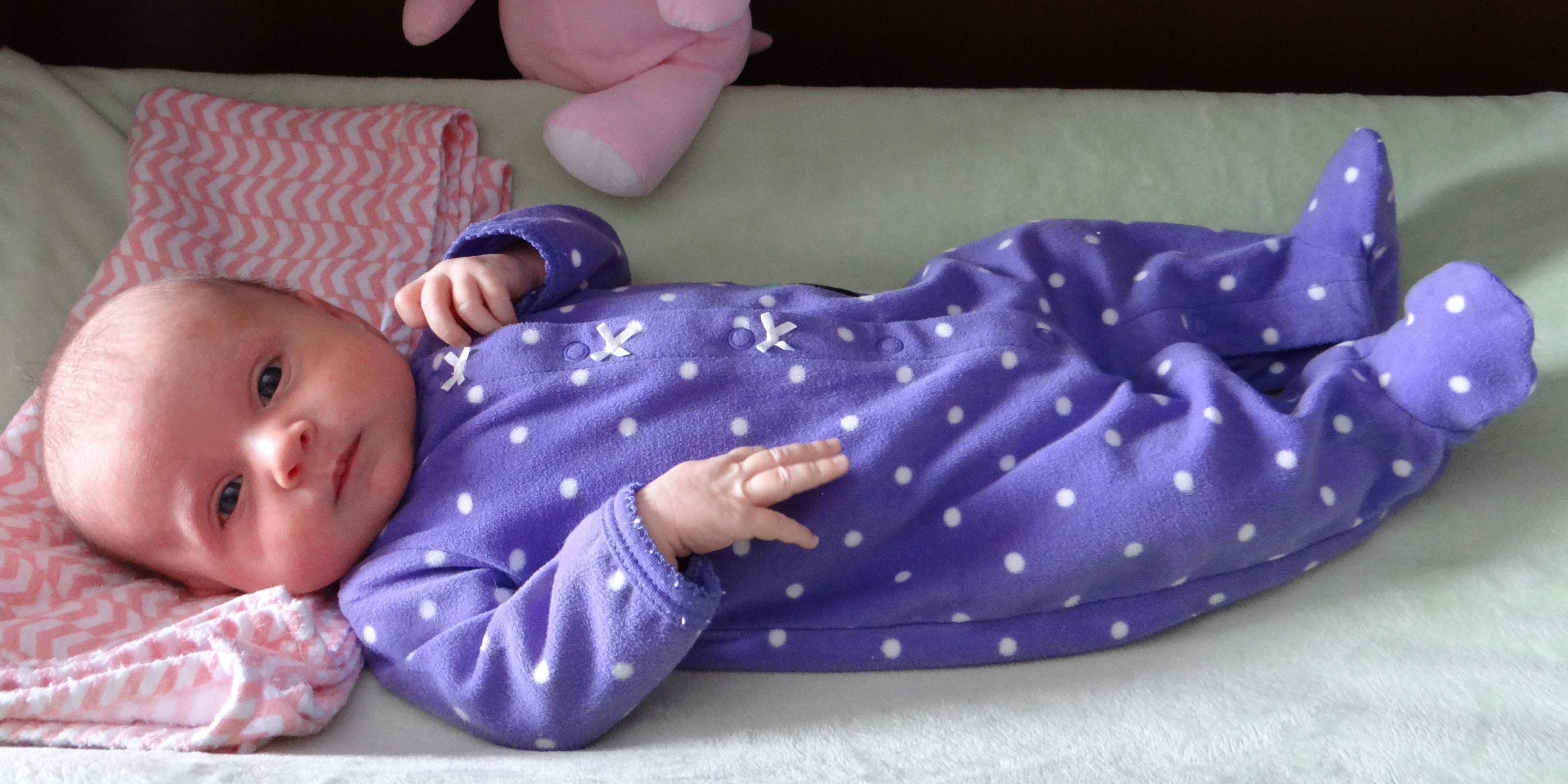Baby wearing Carter's purple sleep and play pajamas