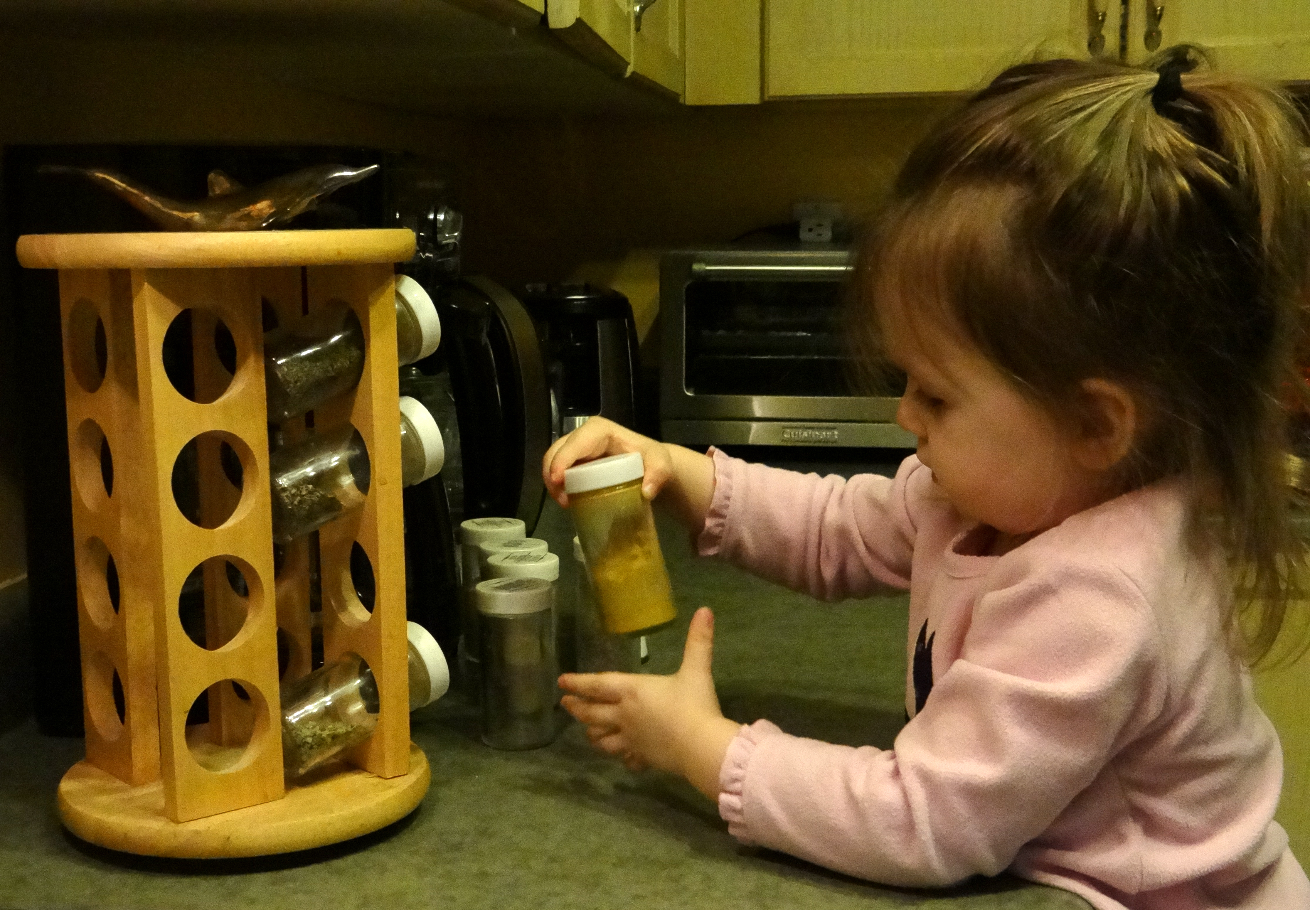 Toddler playing with a spice rack